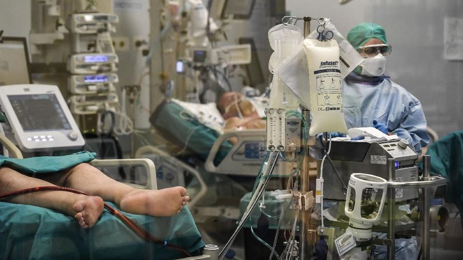 In this photograph taken from behind a window, doctors work on Covid-19 patients in the intensive care unit of San Matteo Hospital, in Pavia, northern Italy, Thursday, March 26, 2020. The San Matteo hospital is where Patient 1, a 38-year-old Unilever worker named Mattia, was kept since he tested positive for Covid-19 on Feb. 21 and opened Italy’s health care crisis. The new coronavirus causes mild or moderate symptoms for most people, but for some, especially older adults and people with existing health problems, it can cause more severe illness or death. (Claudio Furlan/LaPresse via AP)