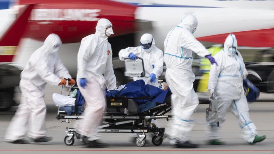 A patient from France who is seriously ill with the coronavirus is transported from an ambulance plane after landing at Dresden International Airport in Dresden, Germany, Saturday, April 4, 2020. For most people, the new coronavirus causes only mild or moderate symptoms, such as fever and cough. For some, especially older adults and people with existing health problems, it can cause more severe illness, including pneumonia.(Robert Michael/dpa via AP)