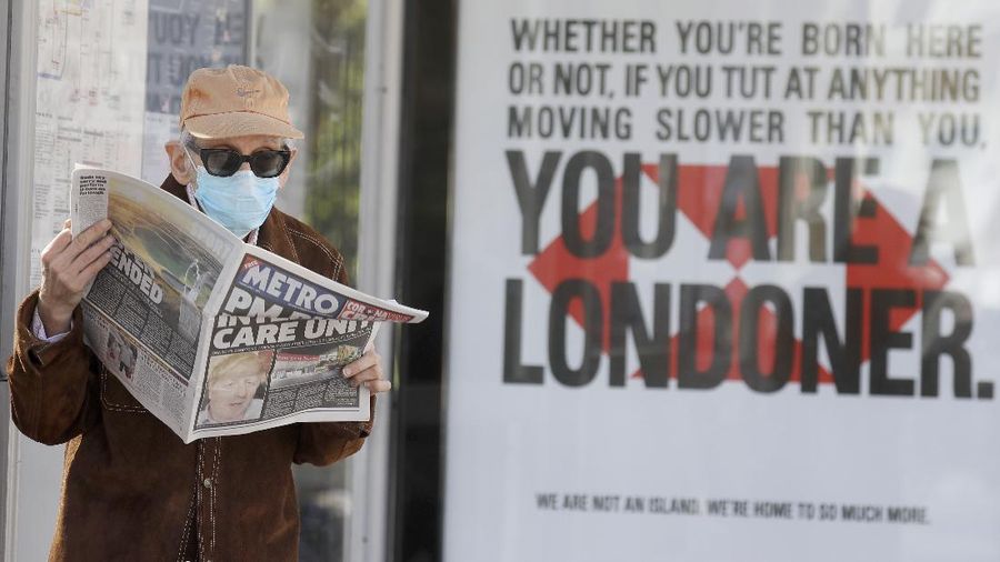 Seorang pria membaca sebuah surat kabar dengan tajuk utama: 'PM dalam perawatan intensif', di luar Rumah Sakit St Thomas 'di London pusat ketika Perdana Menteri Inggris Boris Johnson berada dalam perawatan intensif melawan virus corona di London, (AP/Kirsty Wigglesworth)