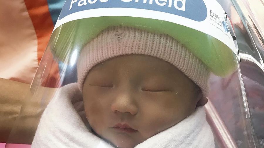 Bayi baru lahir di Thailand menggunakan (face shield) pelindung untuk Cegah Covid-19.