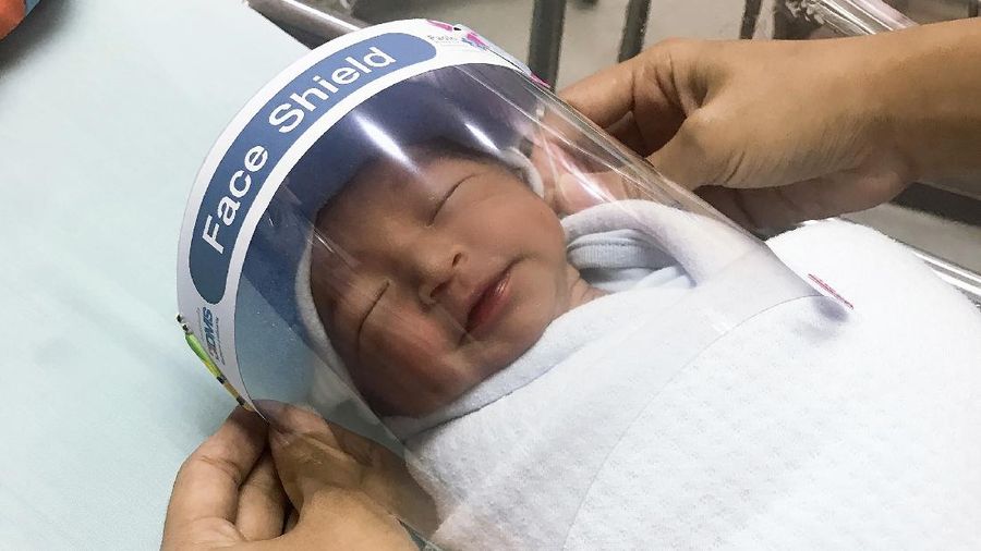 Bayi baru lahir di Thailand menggunakan (face shield) pelindung untuk Cegah Covid-19.