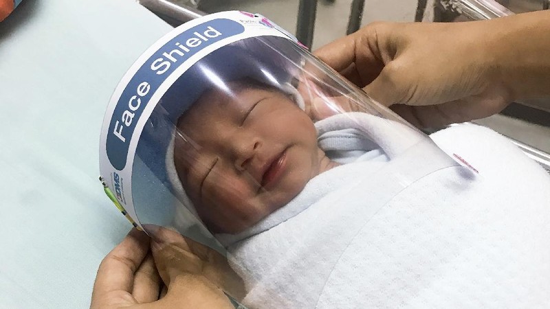 Bayi baru lahir di Thailand menggunakan (face shield) pelindung untuk Cegah Covid-19.