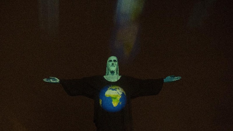 Patung Christ the Redeemer atau patung Yesus Kristus Brasil ini bergambar cahaya tenaga medis sebagai dukungan bagi mereka yang menderita virus corona Covid-19.