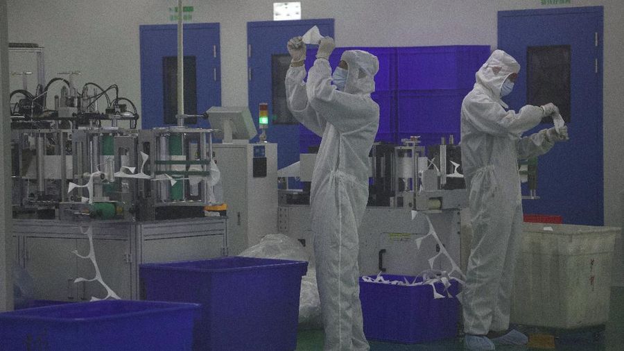 Pekerja memeriksa masker yang diproduksi di jalur produksi Wuhan Zonsen Medical Products Co. Ltd. di Wuhan di provinsi Hubei, China. (AP Photo/Ng Han Guan)