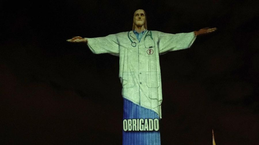 Patung Christ the Redeemer atau patung Yesus Kristus Brasil ini bergambar cahaya tenaga medis sebagai dukungan bagi mereka yang menderita virus corona Covid-19.