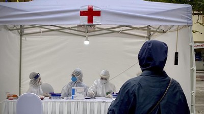 A woman provides test samples at a makeshift COVID-19 testing facility in Hanoi, Vietnam, on Tuesday, Mar. 31, 2020. Vietnam has set up its first makeshift facilities for fast coronavirus testing in residential areas in an effort to detect early infections. (AP Photo/Hau Dinh)
