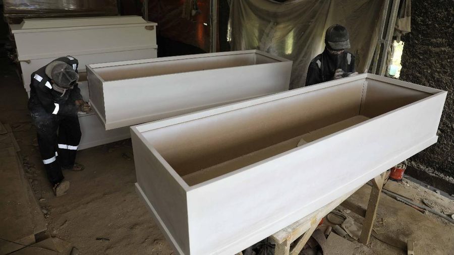 Pekerja memproduksi peti khusus jenazah COVID-19 di Kawasan Ciater, Tangerang Selatan, Banten, Selasa (14/4/2020). Peti mati khusus jenazah COVID-19 tersebut dilapisi alumunium plastik di semua sisi untuk mencegah penyebarannya. (CNBC Indonesia/Andrean Kristianto)
