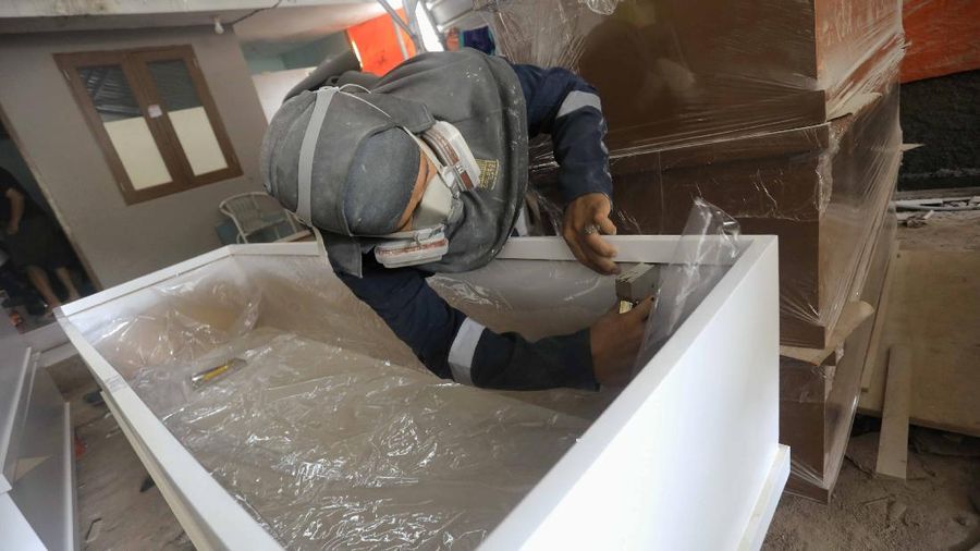 Pekerja memproduksi peti khusus jenazah COVID-19 di Kawasan Ciater, Tangerang Selatan, Banten, Selasa (14/4/2020). Peti mati khusus jenazah COVID-19 tersebut dilapisi alumunium plastik di semua sisi untuk mencegah penyebarannya. (CNBC Indonesia/Andrean Kristianto)