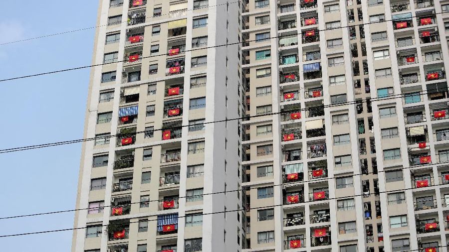 Vietnamese residents hang national flags outside their apartments to support the government in its fight against the new coronavirus in Hanoi, Vietnam Tuesday, April 14, 2020. The new coronavirus causes mild or moderate symptoms for most people, but for some, especially older adults and people with existing health problems, it can cause more severe illness or death. (AP Photo/Hau Dinh)