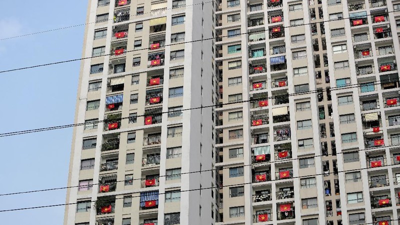 Vietnamese residents hang national flags outside their apartments to support the government in its fight against the new coronavirus in Hanoi, Vietnam Tuesday, April 14, 2020. The new coronavirus causes mild or moderate symptoms for most people, but for some, especially older adults and people with existing health problems, it can cause more severe illness or death. (AP Photo/Hau Dinh)