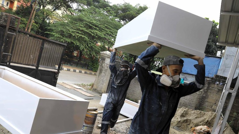 Pekerja memproduksi peti khusus jenazah COVID-19 di Kawasan Ciater, Tangerang Selatan, Banten, Selasa (14/4/2020). Peti mati khusus jenazah COVID-19 tersebut dilapisi alumunium plastik di semua sisi untuk mencegah penyebarannya. (CNBC Indonesia/Andrean Kristianto)