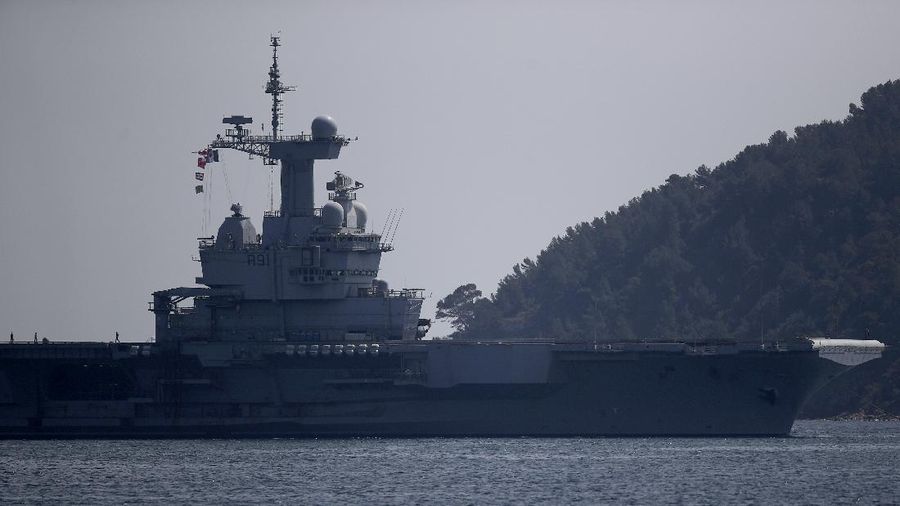 The French aircraft carrier Charles de Gaulle arrives in the bay of Toulon, southern France, Sunday April 12, 2020. The Defense Ministry said in a statement that around 40 sailors showed symptoms compatible with COVID-19, the disease the coronavirus causes. The new coronavirus causes mild or moderate symptoms for most people, but for some, especially older adults and people with existing health problems, it can cause more severe illness or death. (AP Photo/Daniel Cole)