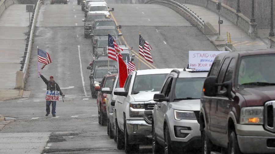 A Trump Unity sign on a trailer is shown parked at a protest in front of the Michigan State Capitol in Lansing, Mich., Wednesday, April 15, 2020. Flag-waving, honking protesters drove past the Michigan Capitol on Wednesday to show their displeasure with Gov. Gretchen Whitmer's orders to keep people at home and businesses locked during the new coronavirus COVID-19 outbreak. (AP Photo/Paul Sancya)