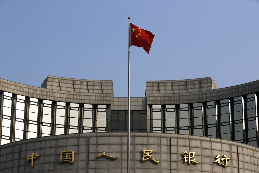 Seorang pria berjalan melewati bank sentral China, atau People's Bank of China, di Beijing, Minggu, 10 Maret 2019.  (AP/Andy Wong)