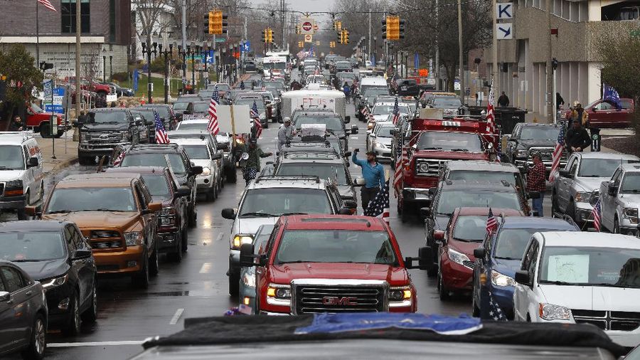 Demo warga Michigan, Amerika Serikat wujud kekecewaan warga setelah Gubernur Michigan memerintahkan warga tetap di rumah guna mencegah penyebaran virus corona (Covid-19). (AP Photo/Paul Sancya) A Trump Unity sign on a trailer is shown parked at a protest in front of the Michigan State Capitol in Lansing, Mich., Wednesday, April 15, 2020. Flag-waving, honking protesters drove past the Michigan Capitol on Wednesday to show their displeasure with Gov. Gretchen Whitmer's orders to keep people at home and businesses locked during the new coronavirus COVID-19 outbreak. (AP Photo/Paul Sancya)