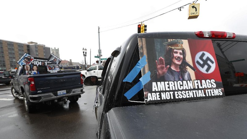 A Trump Unity sign on a trailer is shown parked at a protest in front of the Michigan State Capitol in Lansing, Mich., Wednesday, April 15, 2020. Flag-waving, honking protesters drove past the Michigan Capitol on Wednesday to show their displeasure with Gov. Gretchen Whitmer's orders to keep people at home and businesses locked during the new coronavirus COVID-19 outbreak. (AP Photo/Paul Sancya)