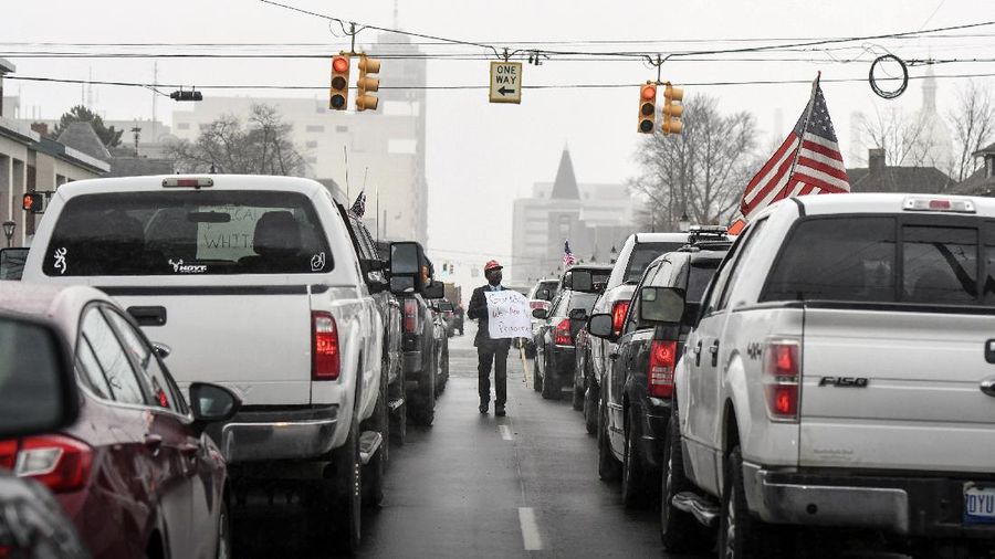 A Trump Unity sign on a trailer is shown parked at a protest in front of the Michigan State Capitol in Lansing, Mich., Wednesday, April 15, 2020. Flag-waving, honking protesters drove past the Michigan Capitol on Wednesday to show their displeasure with Gov. Gretchen Whitmer's orders to keep people at home and businesses locked during the new coronavirus COVID-19 outbreak. (AP Photo/Paul Sancya)