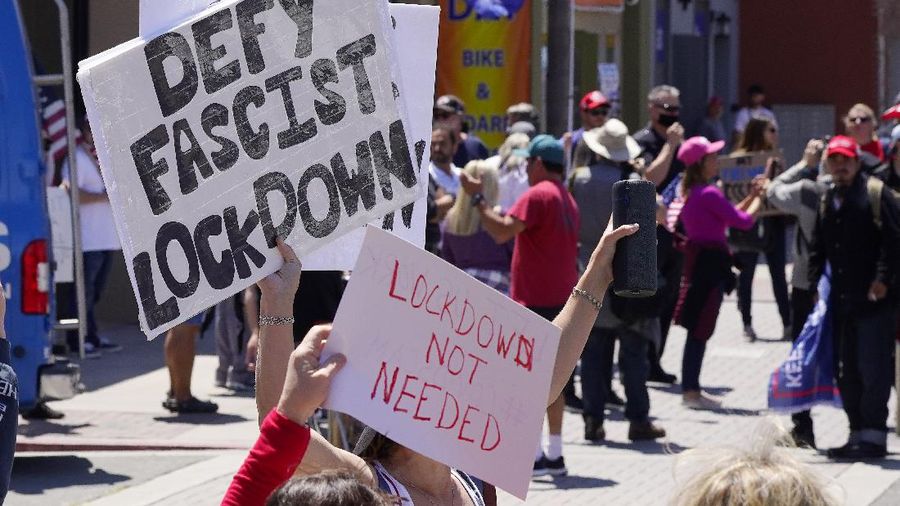 Protesters demonstrate against stay-at-home orders that were put in place due to the COVID-19 outbreak, Friday, April 17, 2020, in Huntington Beach, Calif. (AP Photo/Mark J. Terrill)