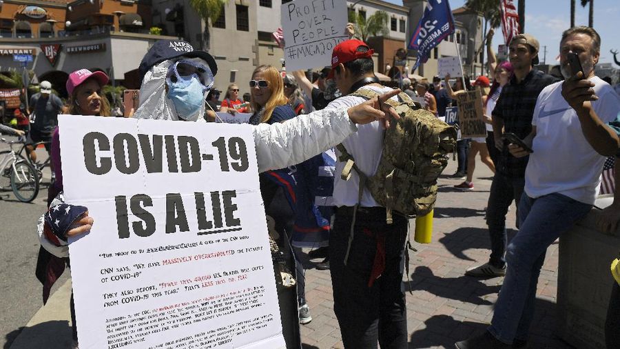 Protesters demonstrate against stay-at-home orders that were put in place due to the COVID-19 outbreak, Friday, April 17, 2020, in Huntington Beach, Calif. (AP Photo/Mark J. Terrill)