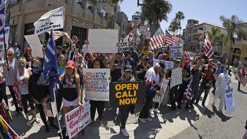 Protesters demonstrate against stay-at-home orders that were put in place due to the COVID-19 outbreak, Friday, April 17, 2020, in Huntington Beach, Calif. (AP Photo/Mark J. Terrill)