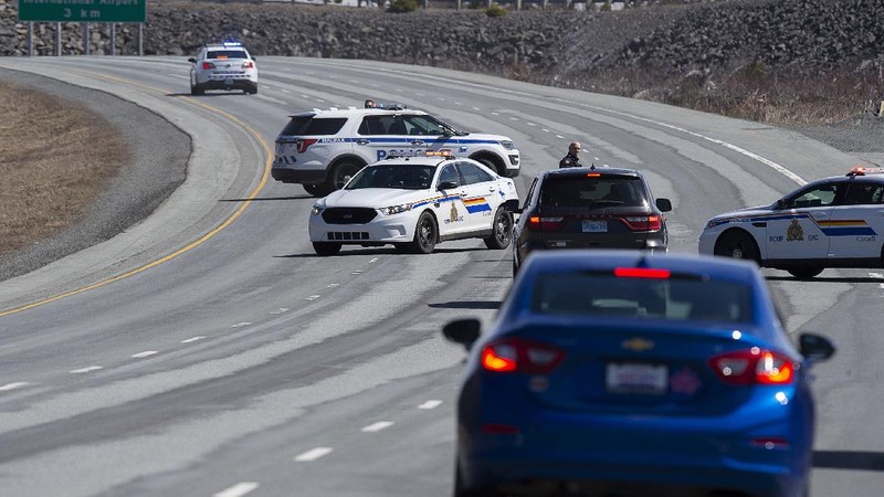 A worker with the medical examiner's office removes a body from a gas bar in Enfield, Nova Scotia, on Sunday, April 19, 2020. A suspect in an active shooter investigation was placed in custody Sunday at an Irving service station in Nova Scotia, after police said there were 