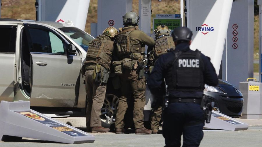 Royal Canadian Mounted Police officers surround a suspect at a gas station in Enfield, Nova Scotia on Sunday April 19, 2020. Canadian police say multiple people are dead plus the suspect after a shooting rampage across the province of Nova Scotia. It was the deadliest shooting in Canada in 30 years. (Tim Krochak/The Canadian Press via AP)