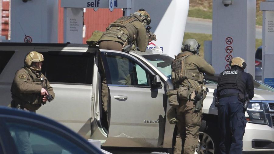 Royal Canadian Mounted Police officers surround a suspect at a gas station in Enfield, Nova Scotia, Sunday April 19, 2020. Canadian police say multiple people are dead plus the suspect after a shooting rampage across the province of Nova Scotia. It was the deadliest shooting in Canada in 30 years. (Tim Krochak/The Canadian Press via AP)