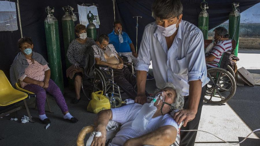 Emma Salvador, 84, supplements her oxygen as her son Jose Gonzalez watches over her in a makeshift tent set up at the 2 de Mayo Hospital to treat people who are infected with the new coronavirus, in Lima, Peru, Friday, April 17, 2020. (AP Photo/Rodrigo Abd)