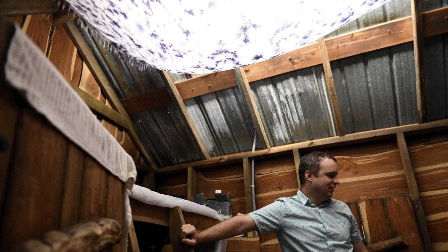 Jason Barnes' fist-bumps with his 6-year-old son, Stiles, against the glass Saturday, April 18, 2020, in Corpus Christi, Texas. Barnes maintains social distancing with his family as long as there are consistent coronavirus cases in the Coastal Bend. (Annie Rice/Corpus Christi Caller-Times via AP)
