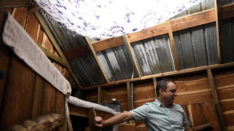 Jason Barnes' fist-bumps with his 6-year-old son, Stiles, against the glass Saturday, April 18, 2020, in Corpus Christi, Texas. Barnes maintains social distancing with his family as long as there are consistent coronavirus cases in the Coastal Bend. (Annie Rice/Corpus Christi Caller-Times via AP)