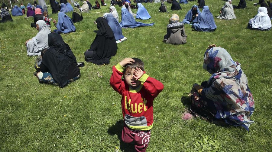 Warga Afghanistan menunggu untuk menerima gandum gratis yang disumbangkan oleh pemerintah Afghanistan menjelang bulan puasa Ramadhan. (AP/Rahmat Gul)