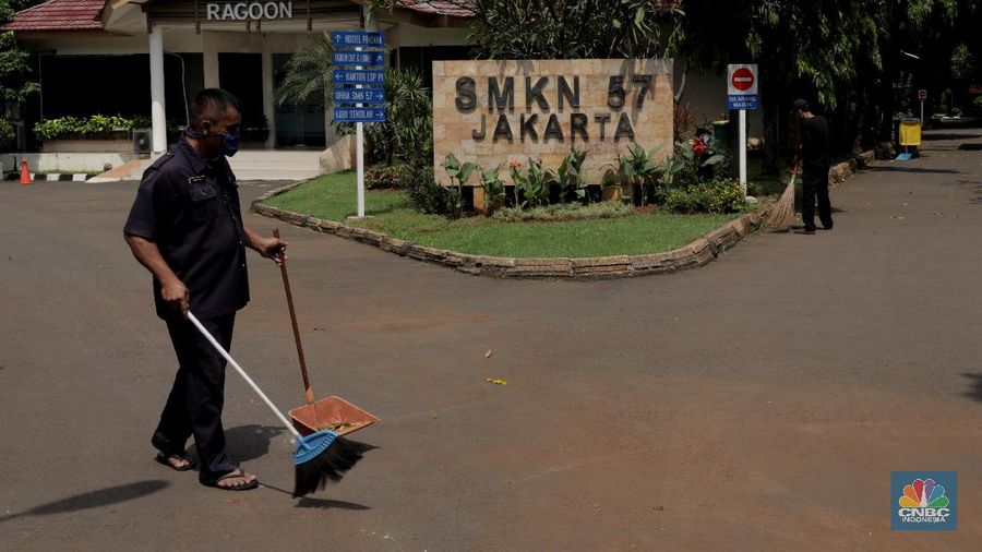 Petugas merapikan ruangan yang akan dijadikan tempat tinggal sementara bagi tenaga medis penanganan Covid-19 di SMKN 57 Jakarta, Rabu (22/4) (CNBC Indonesia/Muhammad Sabki)