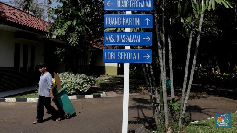 Petugas merapikan ruangan yang akan dijadikan tempat tinggal sementara bagi tenaga medis penanganan Covid-19 di SMKN 57 Jakarta, Rabu (22/4) (CNBC Indonesia/Muhammad Sabki)