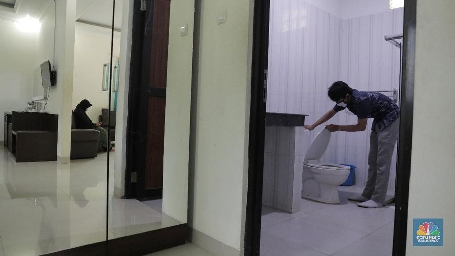 Petugas merapikan ruangan yang akan dijadikan tempat tinggal sementara bagi tenaga medis penanganan Covid-19 di SMKN 57 Jakarta, Rabu (22/4) (CNBC Indonesia/Muhammad Sabki)