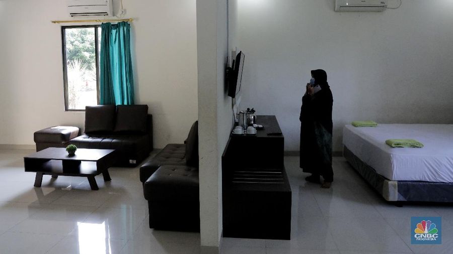Petugas merapikan ruangan yang akan dijadikan tempat tinggal sementara bagi tenaga medis penanganan Covid-19 di SMKN 57 Jakarta, Rabu (22/4) (CNBC Indonesia/Muhammad Sabki)