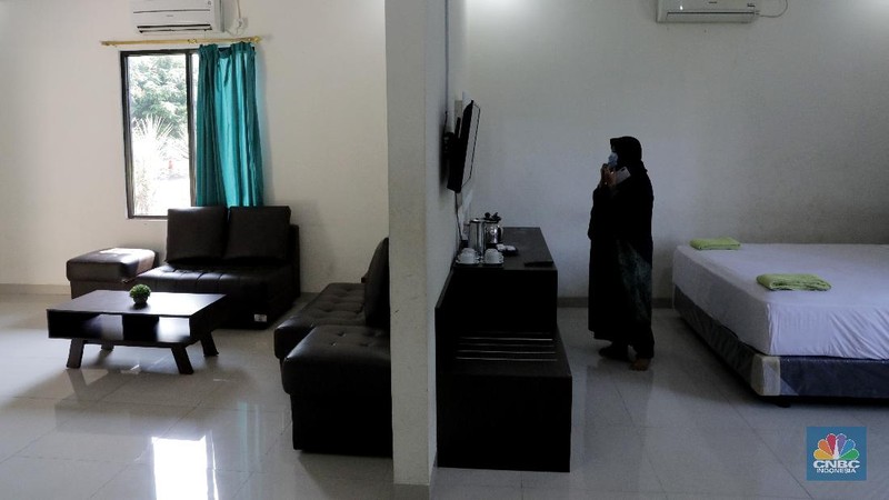 Petugas merapikan ruangan yang akan dijadikan tempat tinggal sementara bagi tenaga medis penanganan Covid-19 di SMKN 57 Jakarta, Rabu (22/4) (CNBC Indonesia/Muhammad Sabki)