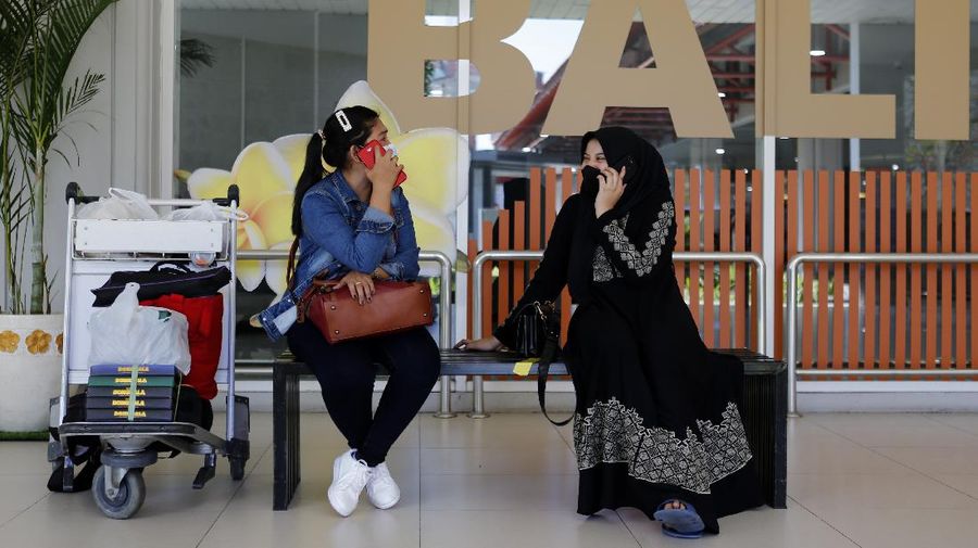 Police officers stand guard at the Ngurah Rai airport, Friday, April 24, 2020, in Bali, Indonesia. Indonesia is suspending passenger flights and rail service as it restricts people in the world's most populous Muslim nation from traveling to their hometowns during the Islamic holy month of Ramadan because of the coronavirus outbreak. (AP Photo/Firdia Lisnawati)