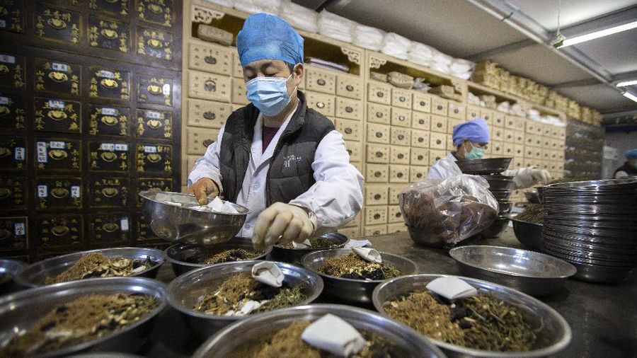 In this March 13, 2020 photo, bowls containing prescriptions for traditional Chinese medicine preparations are stacked on a counter at the Bo Ai Tang traditional Chinese medicine clinic in Beijing. With no approved drugs for the new coronavirus, some people are turning to alternative medicines, often with governments promoting them. (AP Photo/Mark Schiefelbein)