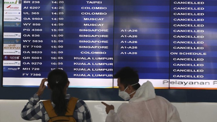 A man sits an empty arrival gate at Soekarno-Hatta International Airport in Tangerang, Indonesia, Indonesia on Friday, April 24, 2020. Indonesia is suspending passenger flights and rail service as it restricts people in the world's most populous Muslim nation from traveling to their hometowns during the Islamic holy month of Ramadan because of the coronavirus outbreak.(AP Photo/Tatan Syuflana)
