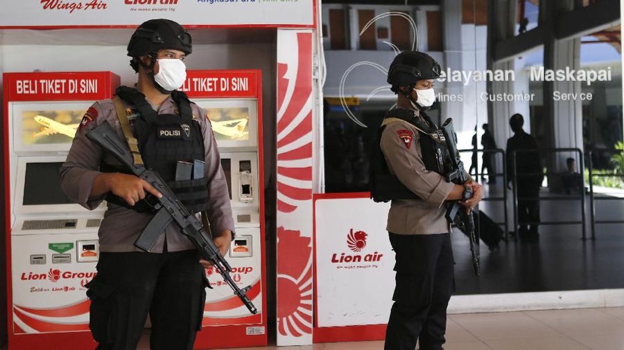 Police officers stand guard at the Ngurah Rai airport, Friday, April 24, 2020, in Bali, Indonesia. Indonesia is suspending passenger flights and rail service as it restricts people in the world's most populous Muslim nation from traveling to their hometowns during the Islamic holy month of Ramadan because of the coronavirus outbreak. (AP Photo/Firdia Lisnawati)