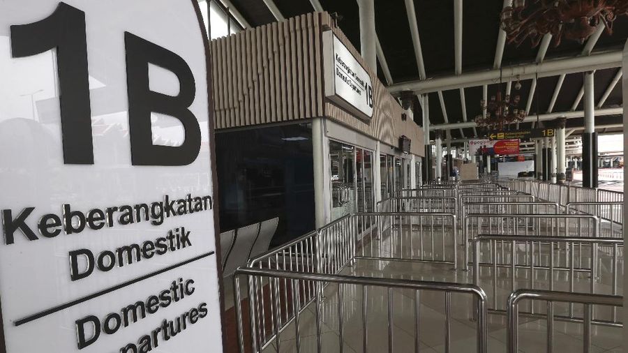 A man sits an empty arrival gate at Soekarno-Hatta International Airport in Tangerang, Indonesia, Indonesia on Friday, April 24, 2020. Indonesia is suspending passenger flights and rail service as it restricts people in the world's most populous Muslim nation from traveling to their hometowns during the Islamic holy month of Ramadan because of the coronavirus outbreak.(AP Photo/Tatan Syuflana)