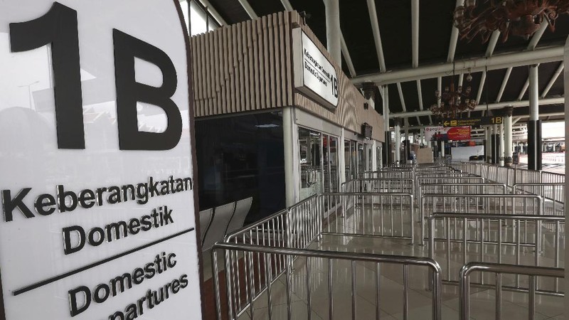 A man sits an empty arrival gate at Soekarno-Hatta International Airport in Tangerang, Indonesia, Indonesia on Friday, April 24, 2020. Indonesia is suspending passenger flights and rail service as it restricts people in the world's most populous Muslim nation from traveling to their hometowns during the Islamic holy month of Ramadan because of the coronavirus outbreak.(AP Photo/Tatan Syuflana)
