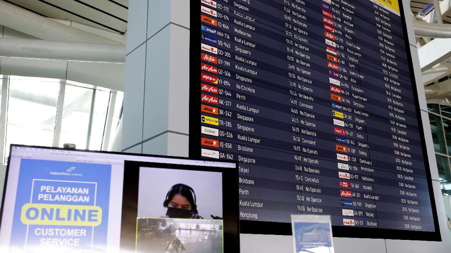 Police officers stand guard at the Ngurah Rai airport, Friday, April 24, 2020, in Bali, Indonesia. Indonesia is suspending passenger flights and rail service as it restricts people in the world's most populous Muslim nation from traveling to their hometowns during the Islamic holy month of Ramadan because of the coronavirus outbreak. (AP Photo/Firdia Lisnawati)
