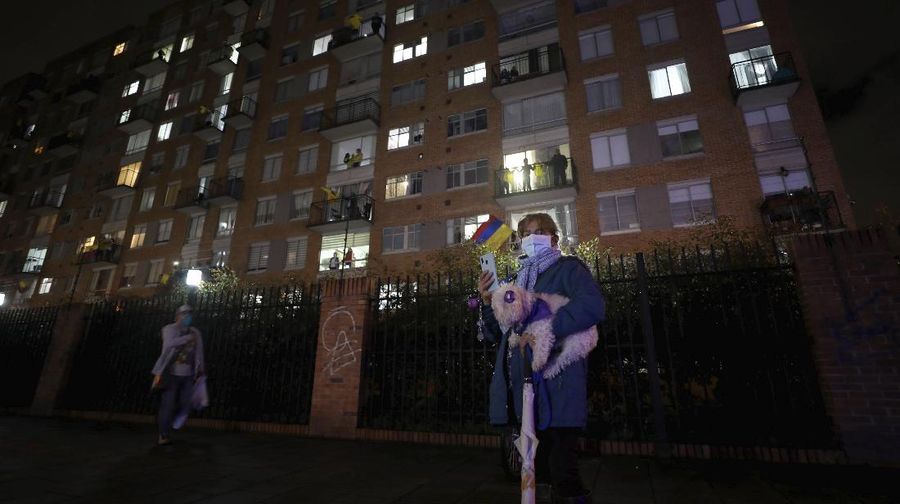 Residents watch a movie from their apartments during a lockdown to help contain the spread of the new coronavirus in Bogota, Colombia, Wednesday, April 22, 2020. The company Cine Colombia set up a giant screen so that people can enjoy a movie projected outside from the comfort and safety of their apartment balconies. (AP Photo/Fernando Vergara)