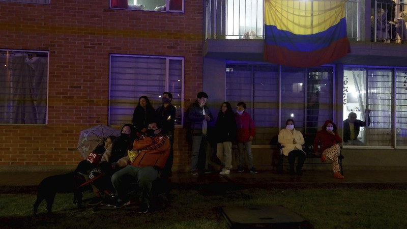 Residents watch a movie from their apartments during a lockdown to help contain the spread of the new coronavirus in Bogota, Colombia, Wednesday, April 22, 2020. The company Cine Colombia set up a giant screen so that people can enjoy a movie projected outside from the comfort and safety of their apartment balconies. (AP Photo/Fernando Vergara)