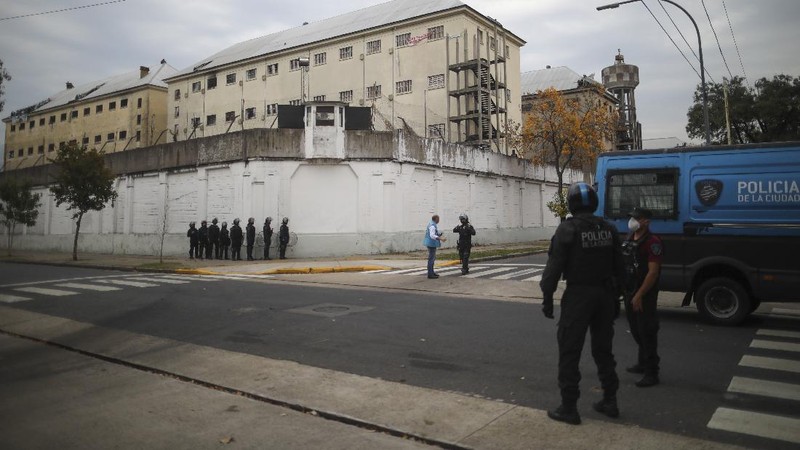 Rioting inmates stand on the roof of the Villa Devoto prison as they protest against authorities who they say are not doing enough to prevent the spread of the new coronavirus, in Buenos Aires, Argentina, Friday, April 24, 2020. (AP Photo/Natacha Pisarenko)