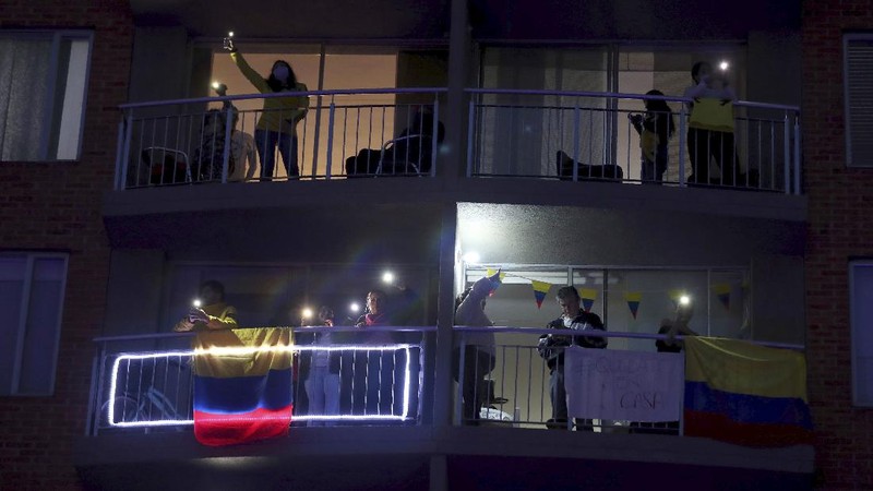 Residents watch a movie from their apartments during a lockdown to help contain the spread of the new coronavirus in Bogota, Colombia, Wednesday, April 22, 2020. The company Cine Colombia set up a giant screen so that people can enjoy a movie projected outside from the comfort and safety of their apartment balconies. (AP Photo/Fernando Vergara)