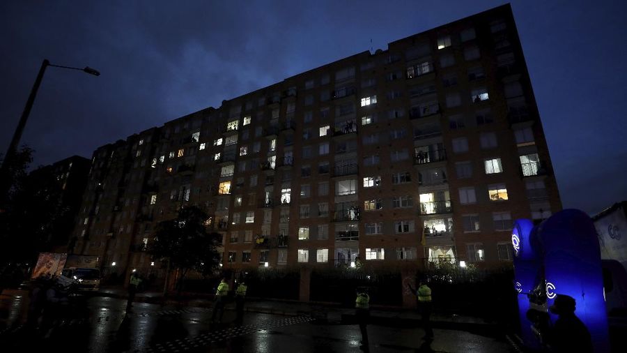Residents watch a movie from their apartments during a lockdown to help contain the spread of the new coronavirus in Bogota, Colombia, Wednesday, April 22, 2020. The company Cine Colombia set up a giant screen so that people can enjoy a movie projected outside from the comfort and safety of their apartment balconies. (AP Photo/Fernando Vergara)