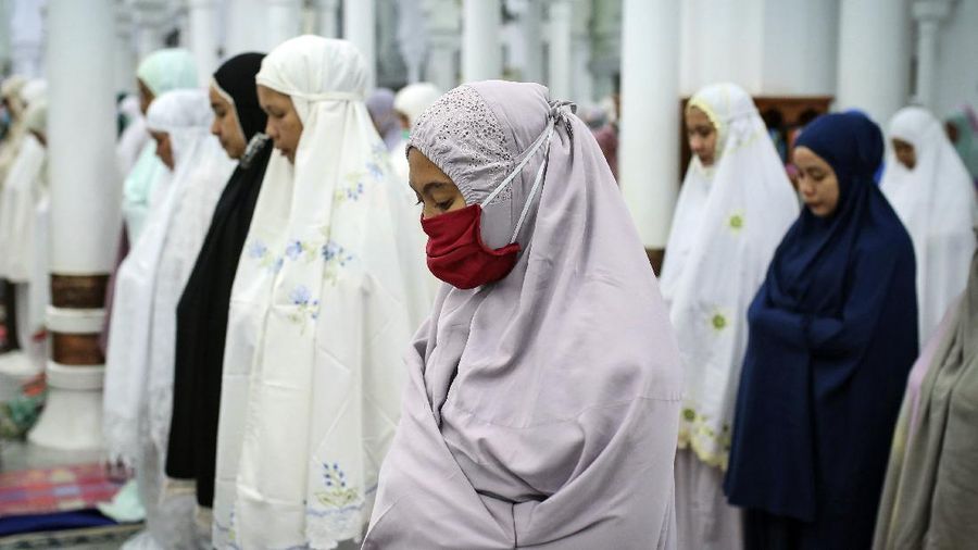 In this photo taken Saturday, April 25, 2020, the family of Bara Tambedou exercises at home after breaking the fast on the first day of the Muslim holy month of Ramadan, in Dakar, Senegal. This year the family is celebrating Ramadan at home, with prohibitions on public gatherings and a dusk-to-dawn curfew in place to curb the spread of the new coronavirus. (AP Photo/Sylvain Cherkaoui)