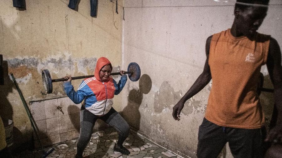 In this photo taken Saturday, April 25, 2020, the family of Bara Tambedou exercises at home after breaking the fast on the first day of the Muslim holy month of Ramadan, in Dakar, Senegal. This year the family is celebrating Ramadan at home, with prohibitions on public gatherings and a dusk-to-dawn curfew in place to curb the spread of the new coronavirus. (AP Photo/Sylvain Cherkaoui)